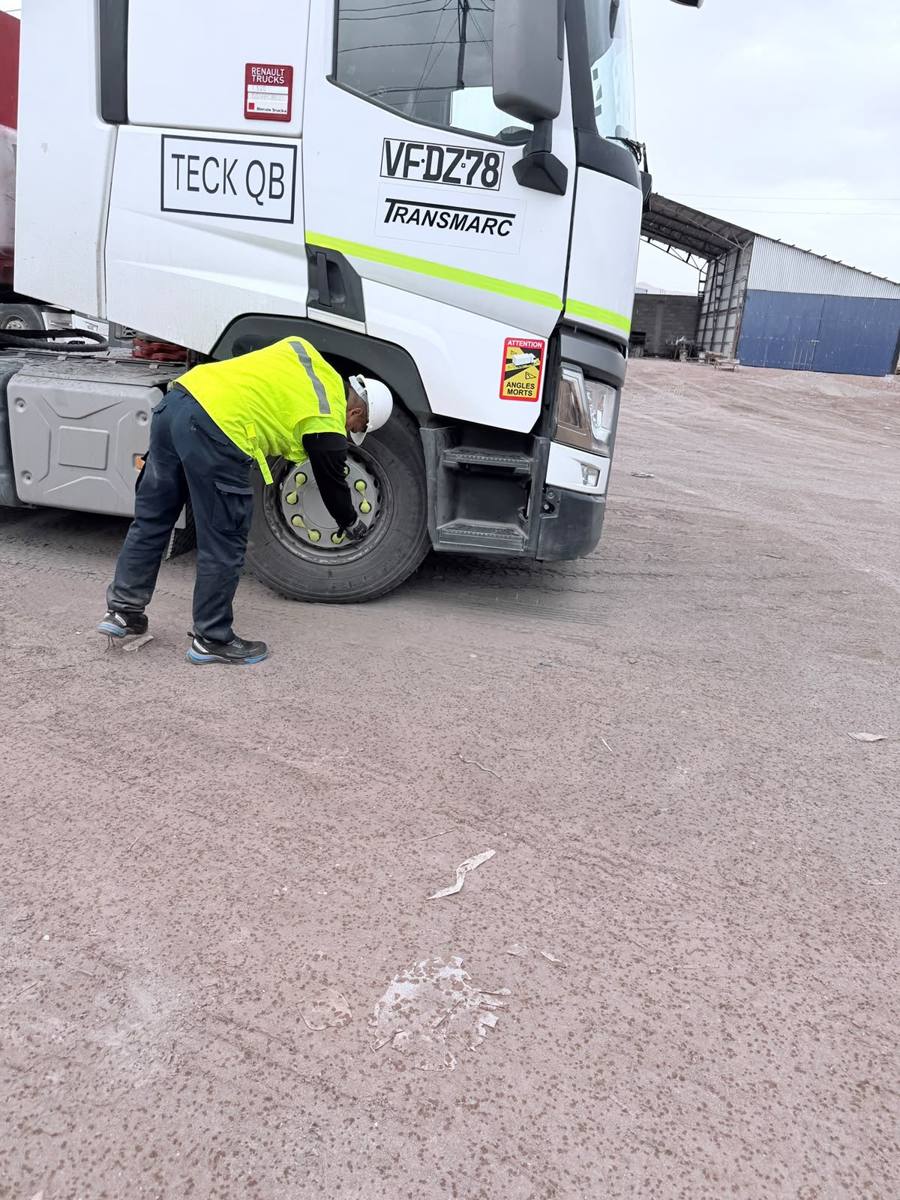 Trabajador con EPP revisando neumáticos