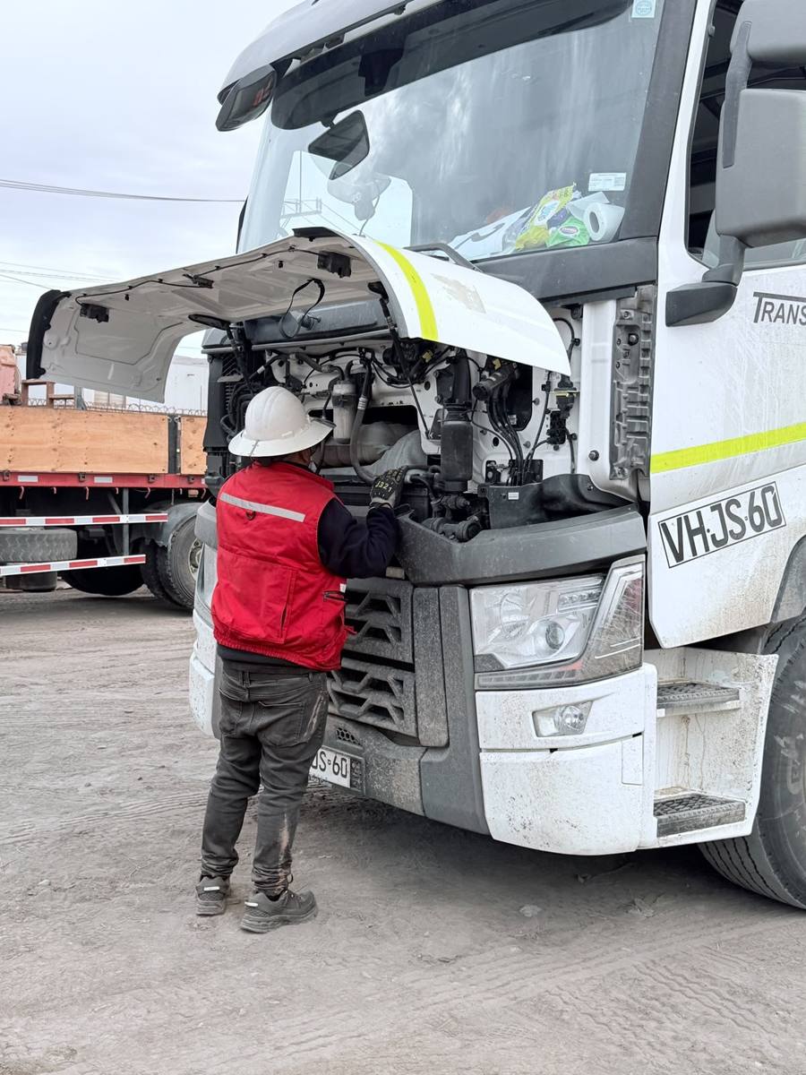 Trabajador con EPP inspeccionando el motor